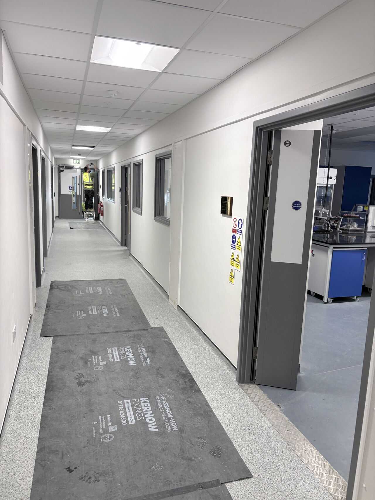 JFD installer working on a laboratory corridor doorset, University of Plymouth Davey Building