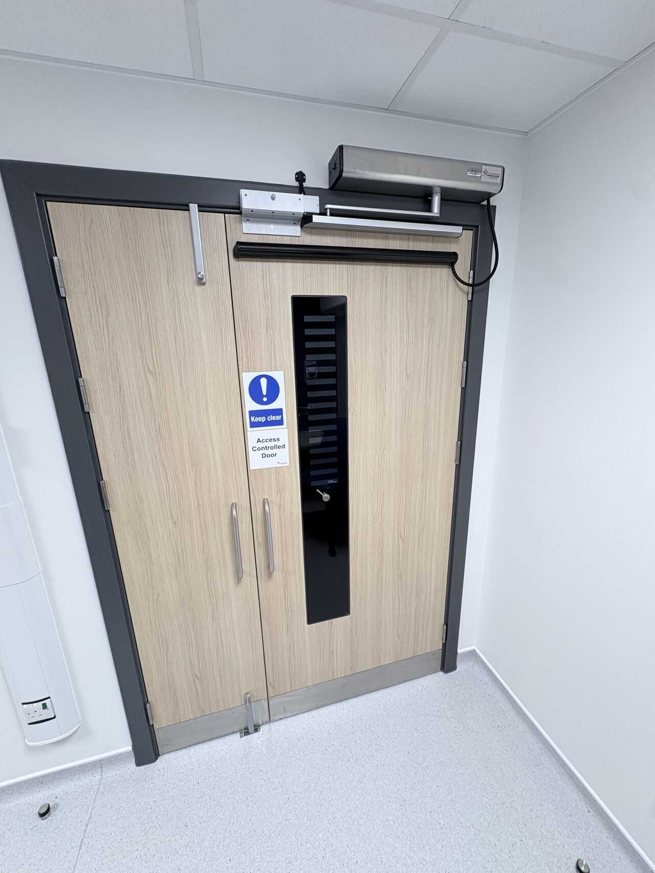 Access-controlled double doorset with powered operator