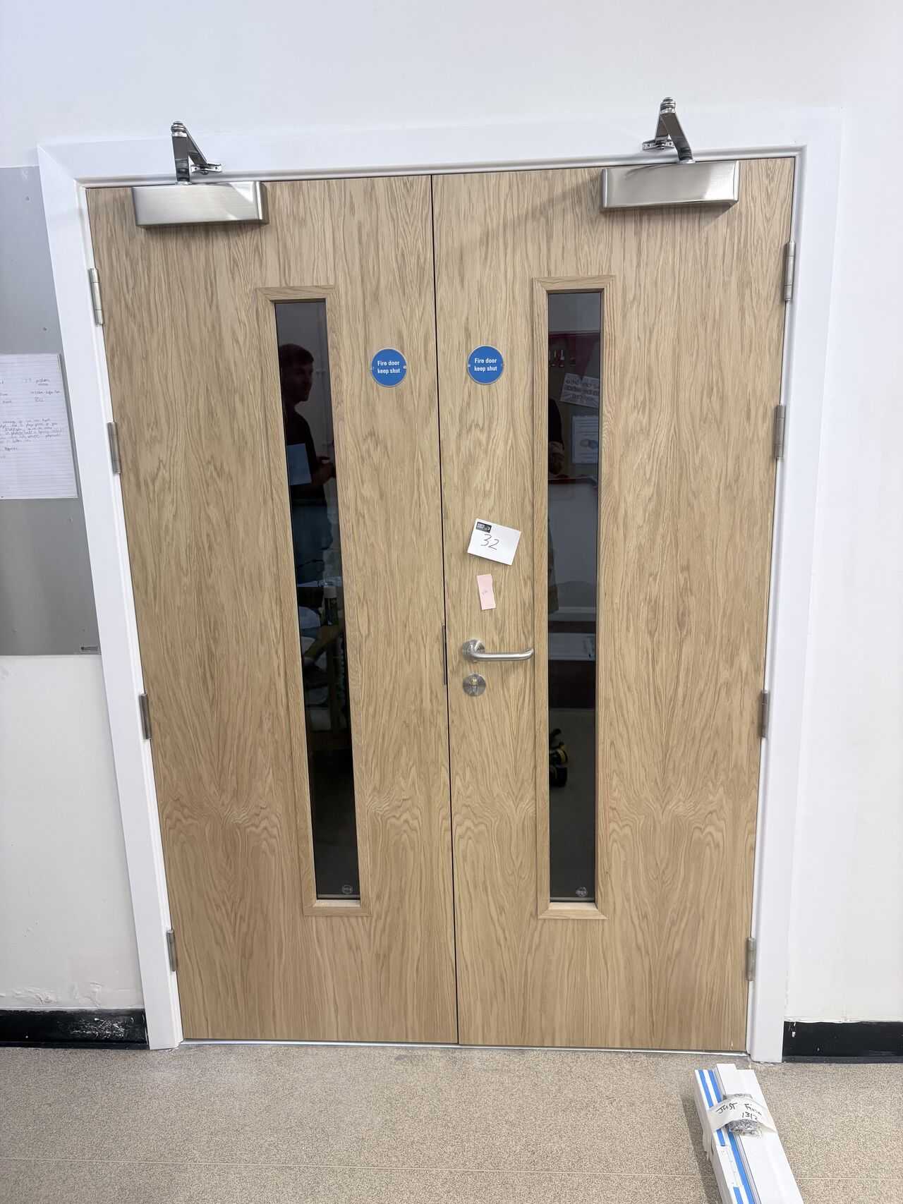 Installed double fire doorset with overhead closers, vision panels, signage and lever furniture, Weston-super-Mare school